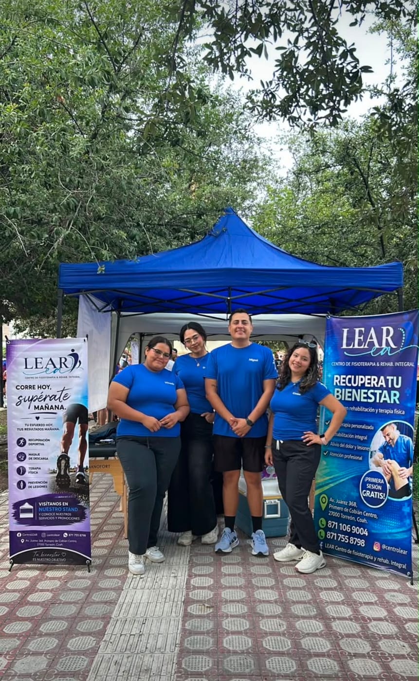Equipo de LEAR frente al stand y banners de la carrera 7K