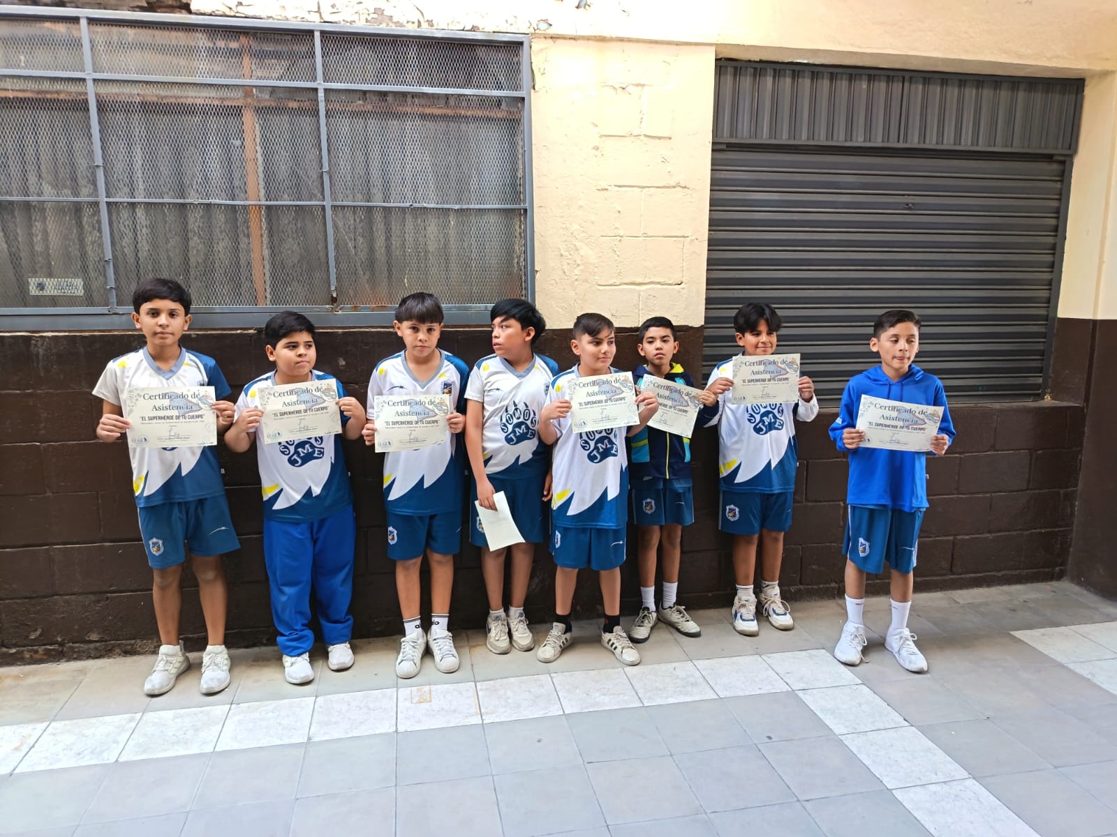 Estudiantes con su certificado de asistencia